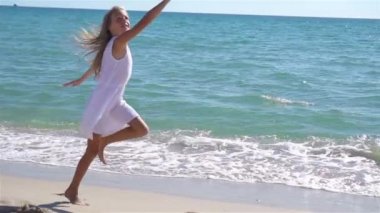 Gün batımında sahilde uçurtma uçuran küçük kız