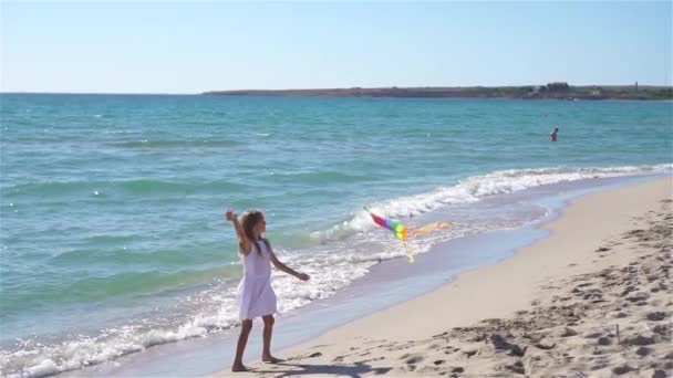 Mała dziewczynka puszczająca latawiec na plaży o zachodzie słońca — Wideo stockowe