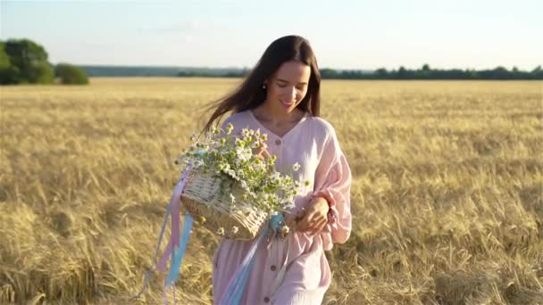 Красивая девушка на пшеничном поле с спелой пшеницей в руках — стоковое видео