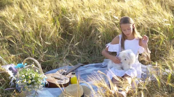 Mooi klein meisje in tarweveld met rijpe tarwe in handen — Stockvideo