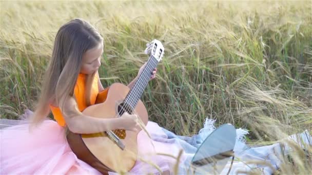 Liebenswertes Vorschulmädchen im Weizenfeld an einem warmen und sonnigen Sommertag — Stockvideo