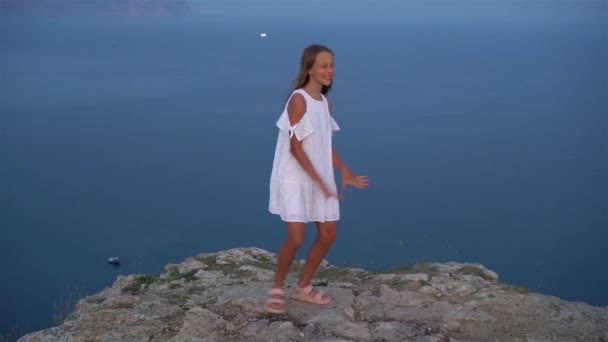 Petite fille au sommet d'une montagne jouissant d'une vue sur la vallée avant le coucher du soleil — Video