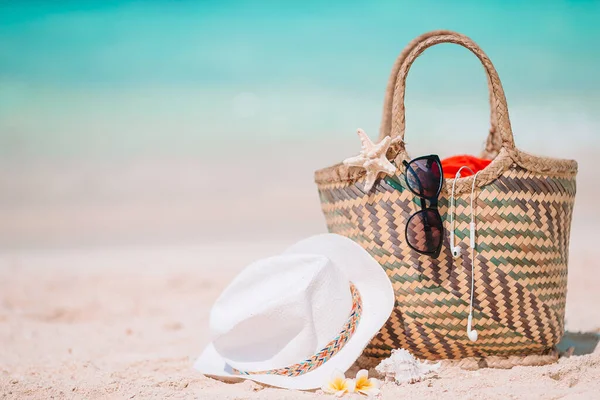 Accesorios de playa - bolsa de paja, sombrero y anteojos en la playa —  Fotos de Stock