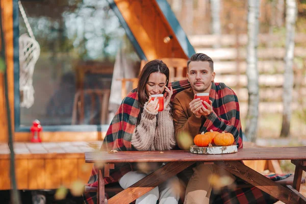 Young couple with coffe on yard of their house at autumn — Stock Photo, Image