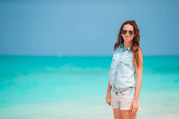 Joven hermosa mujer divirtiéndose en la orilla del mar tropical. Chica feliz fondo el cielo azul y el agua turquesa en el mar en la isla caribeña —  Fotos de Stock