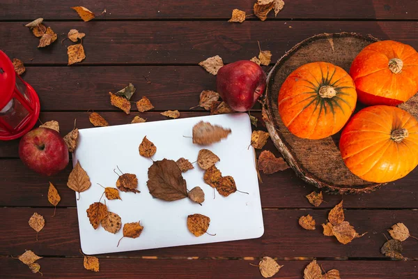 Abóbora cor-de-laranja e folhas perto do computador portátil em uma mesa. Hora da época de outono — Fotografia de Stock