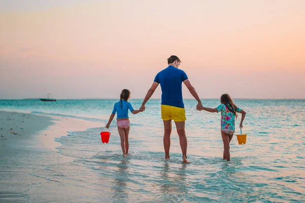 Pai feliz e suas adoráveis filhas na praia tropical se divertindo — Fotografia de Stock