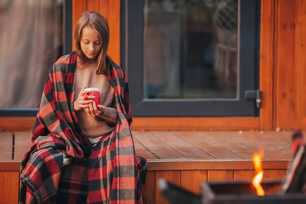 Belle fille enveloppée dans une couverture à l'automne jour chaud — Photo