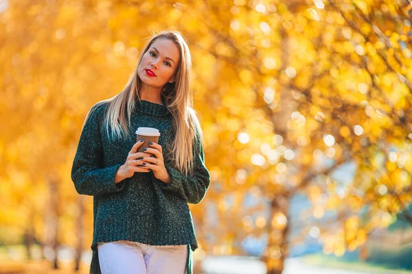Осенняя концепция - красивая женщина в осеннем парке под осенней листвой — стоковое фото