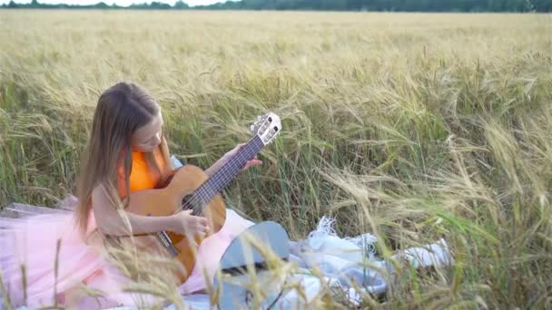 Liebenswertes Vorschulmädchen im Weizenfeld an einem warmen und sonnigen Sommertag — Stockvideo