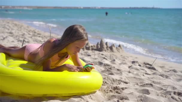 愛らしい女の子オンインフレータブル空気マットレスオンザビーチ — ストック動画
