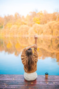 Sonbahar konsepti. Güz parkında göl kenarında güzel bir kız.