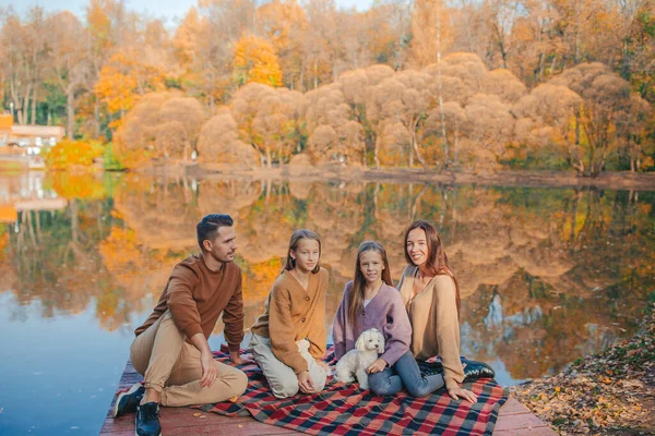 Mooie familie in de herfst warme dag in de buurt van meer — Stockfoto