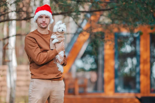 Ung man i Santa hatt bakgrund av trä hus — Stockfoto