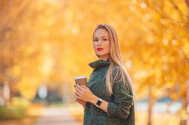 Sonbahar konsepti: Sonbahar parkında sonbahar yeşilliği altında güzel bir kadın.