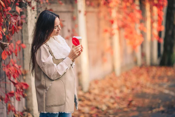 Herfst concept - mooie vrouw die koffie drinkt in het najaar park onder het gebladerte — Stockfoto
