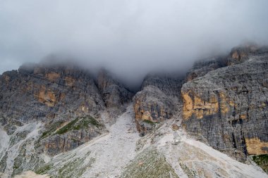 Bulutlar ve buna üzerinden via ferrata Rifugio Duca D'Aosta yakınındaki Ra Bujela geç bir yaz gününde görüldüğü gibi hareketli fırtına ile İtalya, Dolomites Dağları.