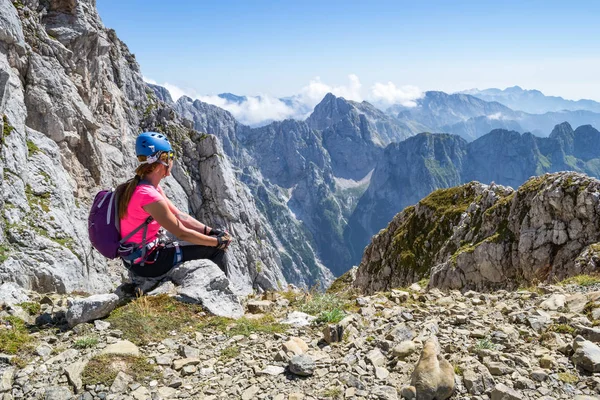 Genç kız üzerinde bir mola sırasında Julian Alps, Triglav Ulusal Parkı, Slovenya, için en yüksek manzarasının tadını bir via ferrata rota, bir sıcak, parlak, yaz gününde