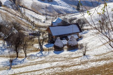 İki haystacks kar, bir vadide Magura köyde izole kırsal bir ev yakınındaki Romanya, güneşli sabahı, hemen sonra kış 2018-2019 sezonun ilk kar kaplı