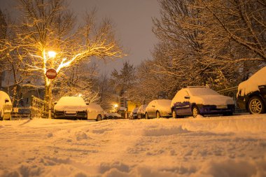 Dar sokakta park edilmiş arabalar, Bükreş, Romanya kar fırtınasında sonra kar ile kaplı. Sonrası ışık, ışık, hiçbir giriş işareti, kış sıcak.