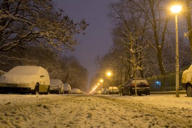 Gece, park etmiş arabaların satırlarının düşük açılı kaplı kar, dar bir sokakta ile yoğun bir kar yağışı sonra - kış saati, Bükreş Romanya