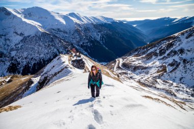 Fagaras dağlarında bir karlı dağ sırtı Romanya, içinde belgili tanımlık geçmiş - yüksek Alp yolu Transfagarasan ile devam kadın hiker Aralık ayında güneşli öğleden sonra