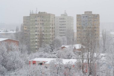 Bükreş, Romanya, güçlü kar fırtınası ile uzun boylu apartmanlar hızla düşen kar gevreği görünür zor. Kış kar fırtınası sırasında eski kentsel binalar.