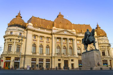 Bucharest, Romanya - 16 Şubat 2019: Merkez Kütüphane Bükreş Üniversitesi (Biblioteca Centrală Universitară Carol 1) ile Kral Carol'ın heykeli önünde gün batımında düşük açılı
