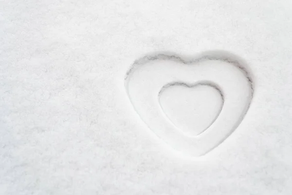 Forma de coração branco em textura de neve com um coração branco menor dentro dele espaço para texto. Tema para: amor, romance, maternidade, Dia dos namorados, Dia das mães, Dia das mulheres, paz, pureza, inverno . — Fotografia de Stock