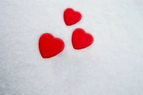 Τρία κόκκινα κουτιά σε σχήμα καρδιάς που σε ένα χιόνι υπόβαθρο, με χώρο για κείμενο. Ιδέα για: αγάπη, οικογένεια, ποικιλομορφία, απογόνων, ειδύλλιο, ελευθερία, θετικό αντίκτυπο, ημέρα της μητέρας, ημέρα της γυναίκας. — Φωτογραφία Αρχείου
