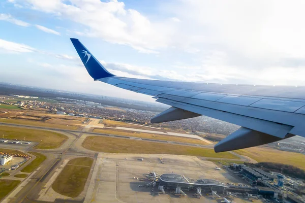 Самолет Blue Air взлетает из международного аэропорта Анри Коанда в городе Отопени, а здание аэропорта видно на земле. Взлет или посадка - редакция . — стоковое фото