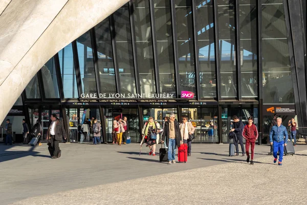 Люди прибывающие и вылетающие на вокзал Лион Сент-Экзюпери (SNCF), с сумками и багажом, в солнечный день. Станция с современной стеклянной архитектурой . — стоковое фото