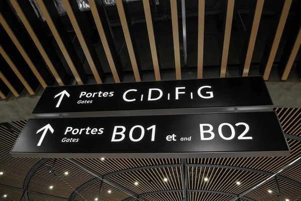 Portas (portes) e flechas sinalizam dentro do Terminal 1 no Aeroporto Internacional Saint Exupery, em Lyon, França. Informações direcionais dentro dos terminais do aeroporto . — Fotografia de Stock