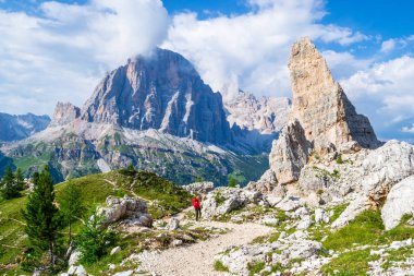 Arka planda Castelletto, Tofana di Rozes, Tofana di Mezzo doğru manzaralı Cinque Torri tur kırmızı sırt çantası ile Kız. Dolomit dağlarında yürüyüş tatili, İtalya.
