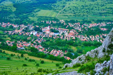 Rimetea köyü, Romanya'nın Trascau Dağları'ndaki Rimetea Climbing Open'ın (Rico) bir parçası olan bir kaya tırmanış ı rotasından görülüyor. Kilise ve geleneksel Transilvanya evleri bir desen oluşturma - havadan görünüm.