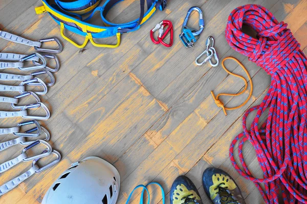 Orta yukarıdan aşağı görünümde metin için boşluk ile spor tırmanma dişli, ahşap arka plan. Kümesi: quickberabere, kask, koşum, Sling, Ayakkabı, halat, Prusik döngü, Quicklinks, bulut cihaz, carabiners.