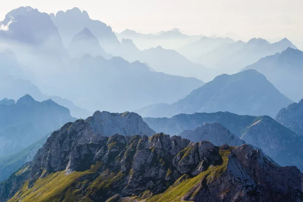 Στρώματα σιλουέτες βουνών και κορυφών στις ιταλικές Άλπεις, το ηλιοβασίλεμα. Θέα από τη διαδρομή προς τα κάτω από την κορυφή Μανκαρτ (Μανκοχ), Ιουλιανές Άλπεις, Triglav, Σλοβενία. — Φωτογραφία Αρχείου