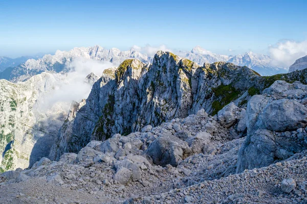 Malowniczy widok w Alpach Julijskich, Słowenia, jak widać z szlaku turystycznego w dół z Mangart szczyt, w Summertime, z jasnym niebieskim słonecznym niebie. — Zdjęcie stockowe