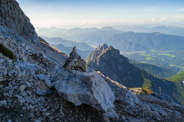 Znacznik szlaku Cairn w pobliżu siodełka Mangarta, Alpy Julijskie, Triglav, Słowenia. Jest to stos wykonany przez człowieka (lub stos) kamieni wykorzystywanych do orientacji, przydatny przy złej pogodzie na szlaku górskim. — Zdjęcie stockowe