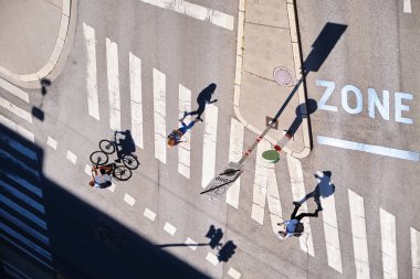 Viyana, Avusturya - 13 Eylül 2019: Kavşakta yürüyen ve bisiklete binen insanların uzun gölgeleri - havadan görünüm.