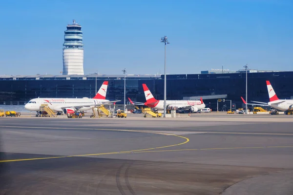 Schwechat, Avusturya - 15 Eylül 2019: Viyana Uluslararası Havaalanı'nda (Vie) avusturya havayolları uçakları, arka ve berrak mavi gökyüzü kontrol kulesi ile.