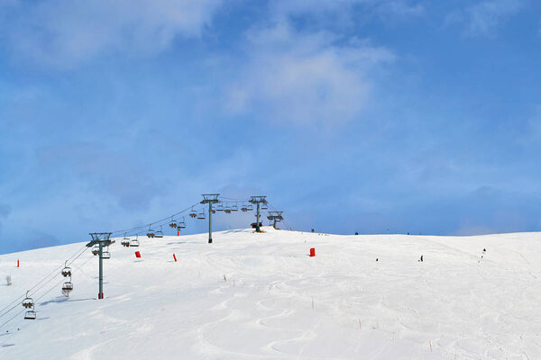 Ski chair lift  in France, with blue sky and few clouds - copy space above.