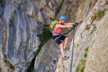 Turda Vadisi 'ndeki (Cheile Turzii) ferrata yoluyla turist, düz kollar ve iyi tırmanma teknikleri kullanarak geçiş yapıyor.