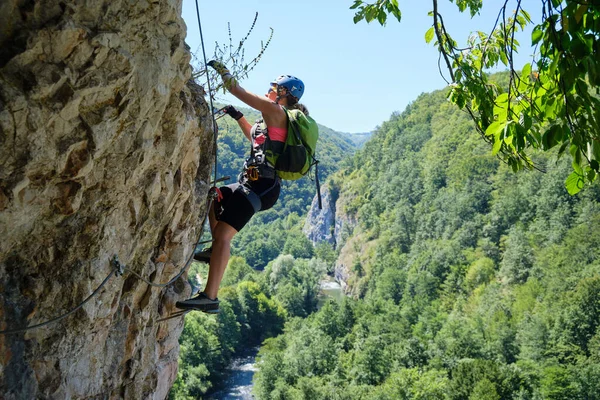 Güneşli bir günde Romanya 'nın Suncuius, Bihor şehrinde ferrata üzerinden giden bir kadın Crisul Repede' nin onu kirlettiği.