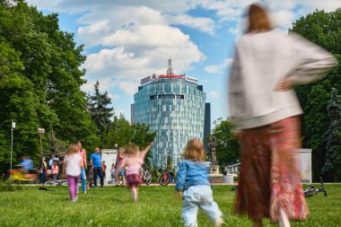 Bükreş, Romanya - 1 Haziran 2020: Herastrau parkında güneşli bir günün tadını çıkaran insanlar, bisikletlerin yanındaki çimenlerde oturup, Covid-19 tecridi kaldırıldıktan sonra küçük gruplar halinde dinleniyorlar.