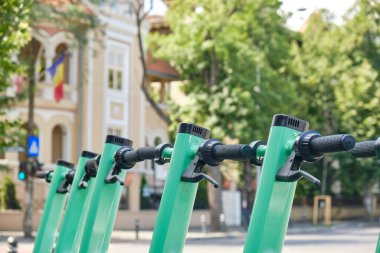 Yeşil-mavi elektrikli scooterlar, şehirlerde daha temiz ve modern bir alternatif ulaşım seçeneği. Kapat..