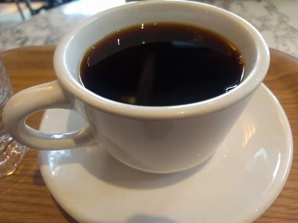 Black coffee in a clear white cup with motion blur