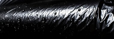 Siyah bir arka plan üzerine su damlaları. Siyah polietilen. Taklit siyah eko-deri.