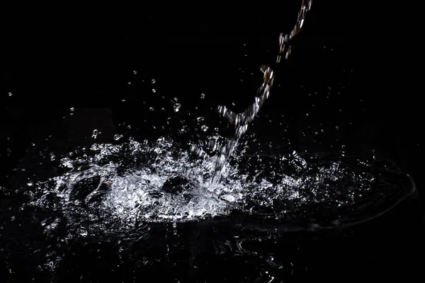 Csobbanás a víz. Izolátum fekete háttérrel — Stock Fotó