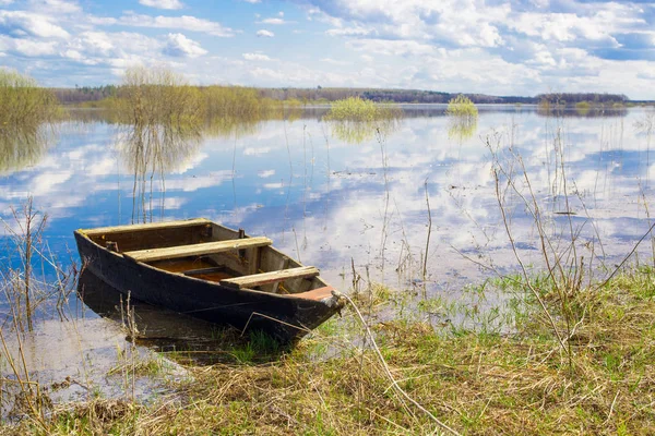 stock image Old wooden boat near the river. Spring flood